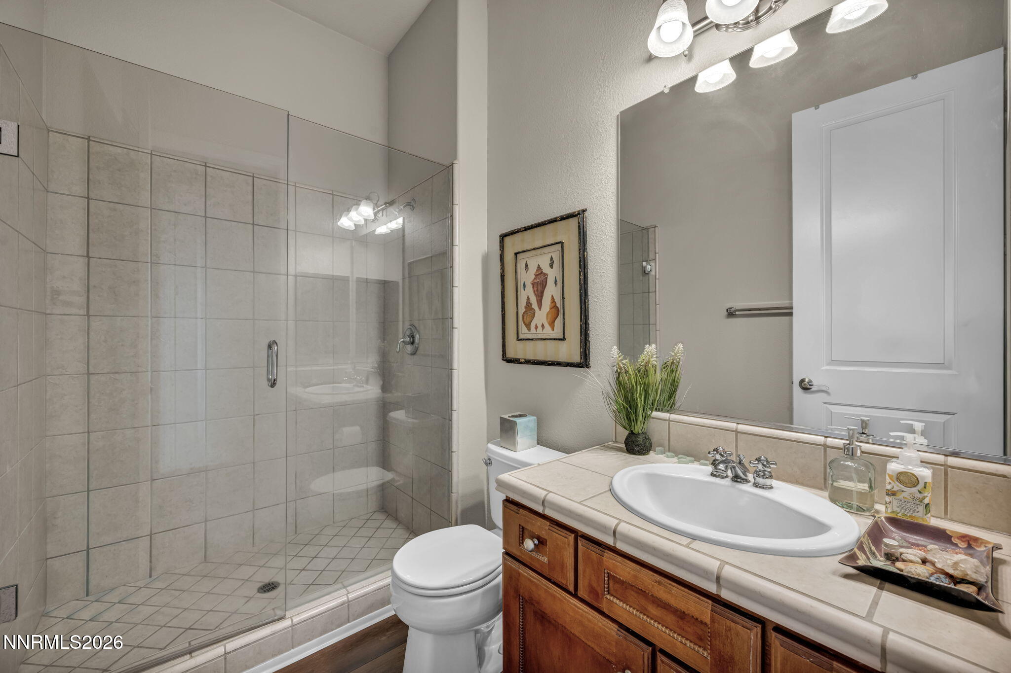 9900 Wilbur May Parkway, Unit 2405 Reno, NV 89521 - Photo 65 of 81 a bathroom with a granite countertop sink a toilet a mirror and shower