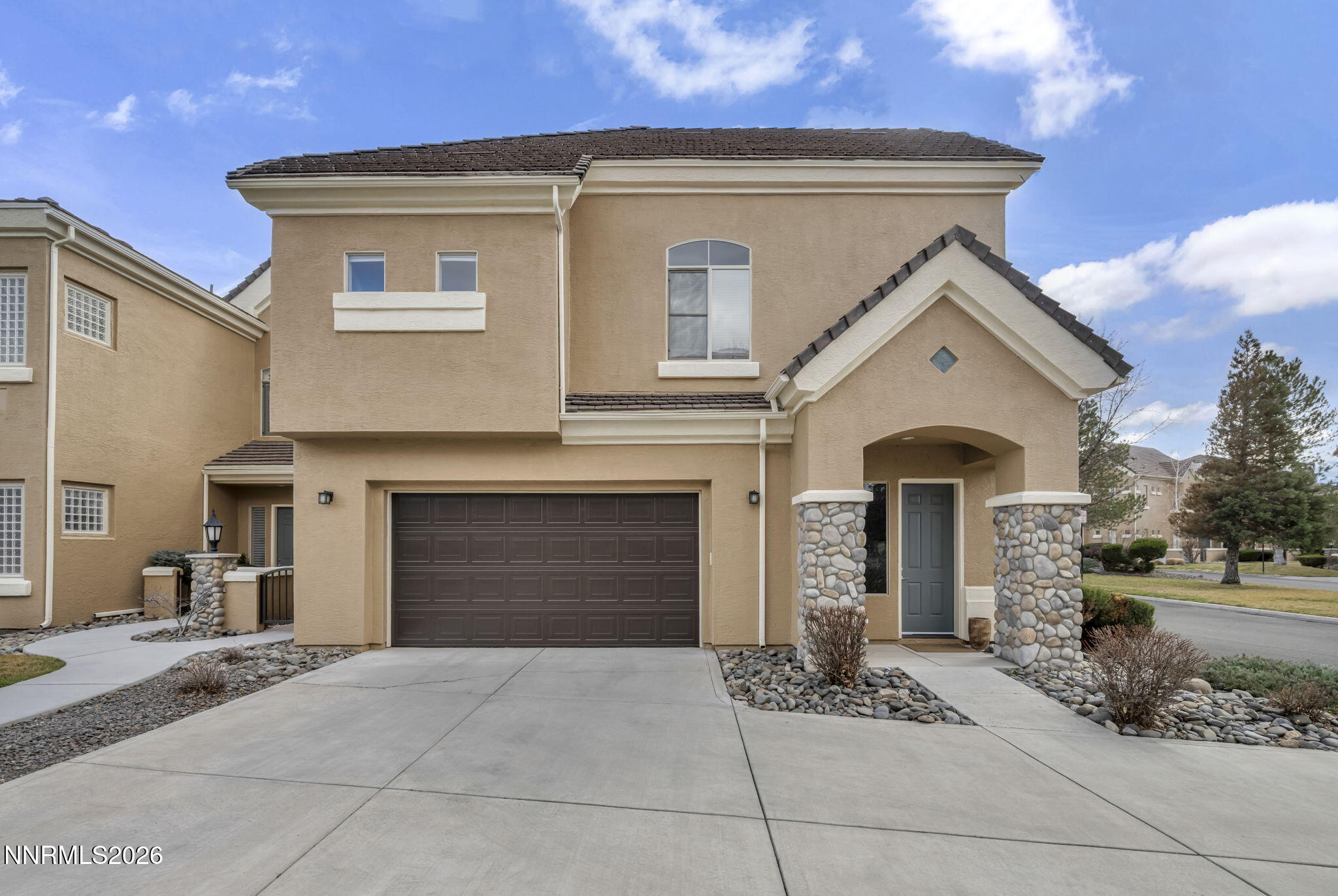 9900 Wilbur May Parkway, Unit 2405 Reno, NV 89521 - Photo 7 of 81 a front view of a house with a yard and garage