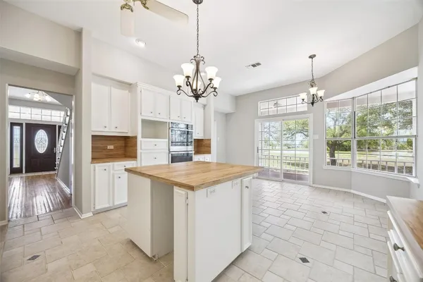 a large white kitchen with cabinets