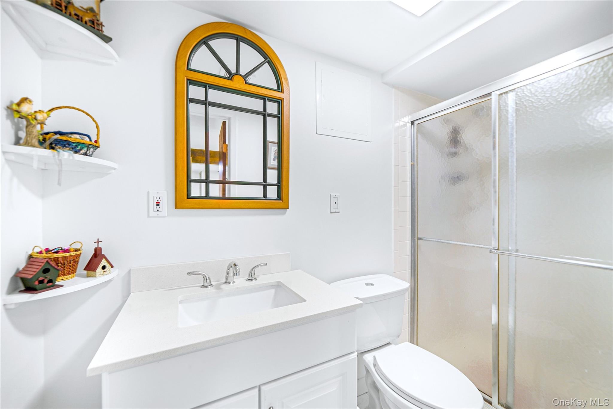 271 Bread And Cheese Hollow Road Northport, NY 11768 - Photo 28 of 32 a bathroom with a sink a mirror and a toilet