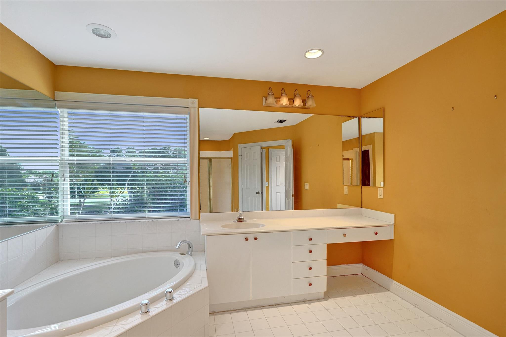 10902 Tamoron Lane Boca Raton, FL 33498 - Photo 38 of 66 a bathroom with a bathtub a sink and a window