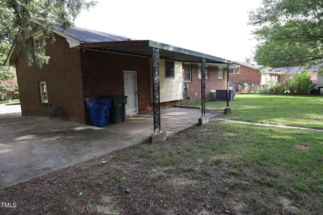 a view of a house with backyard and a tree