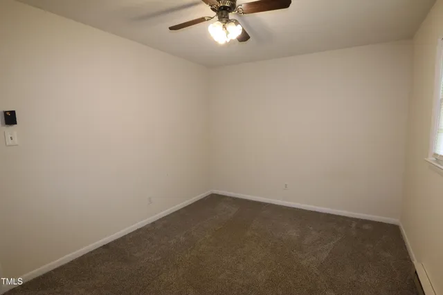 an empty room with a ceiling fan and a window