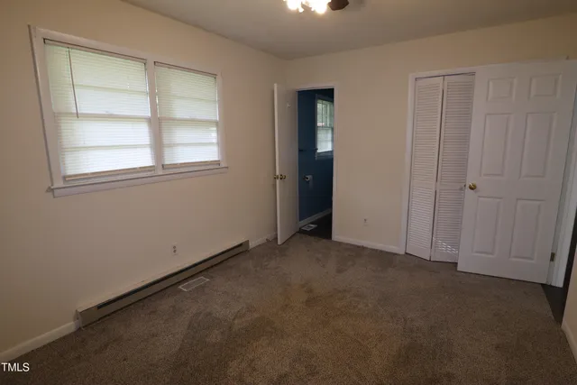 an empty room with windows and closet