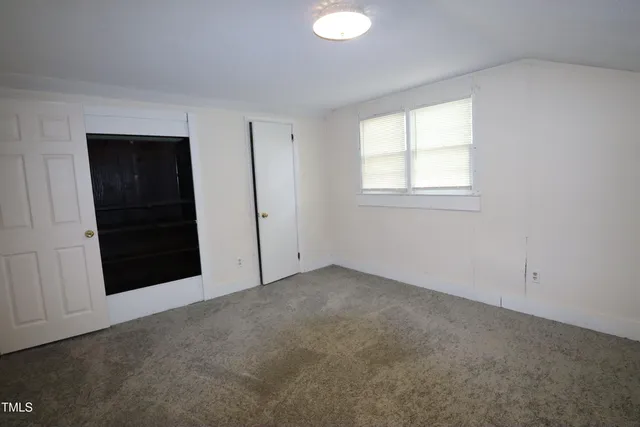 an empty room with windows and closet