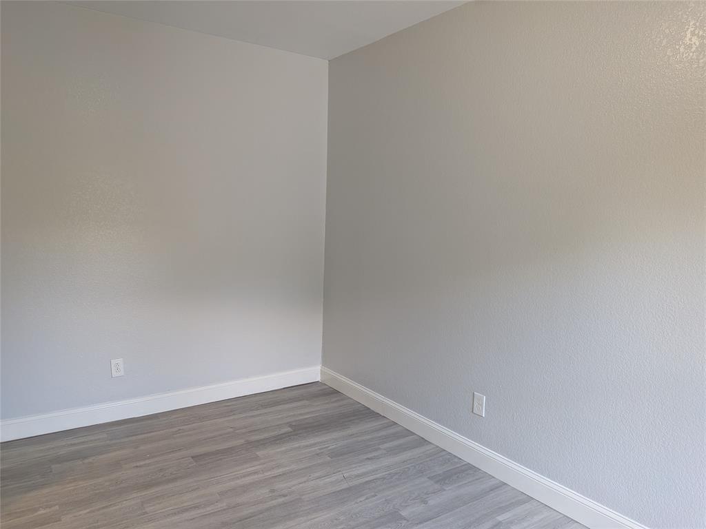 608 Holcomb Road Dallas, TX 75217 - Photo 11 of 23 a view of an empty room with wooden floor