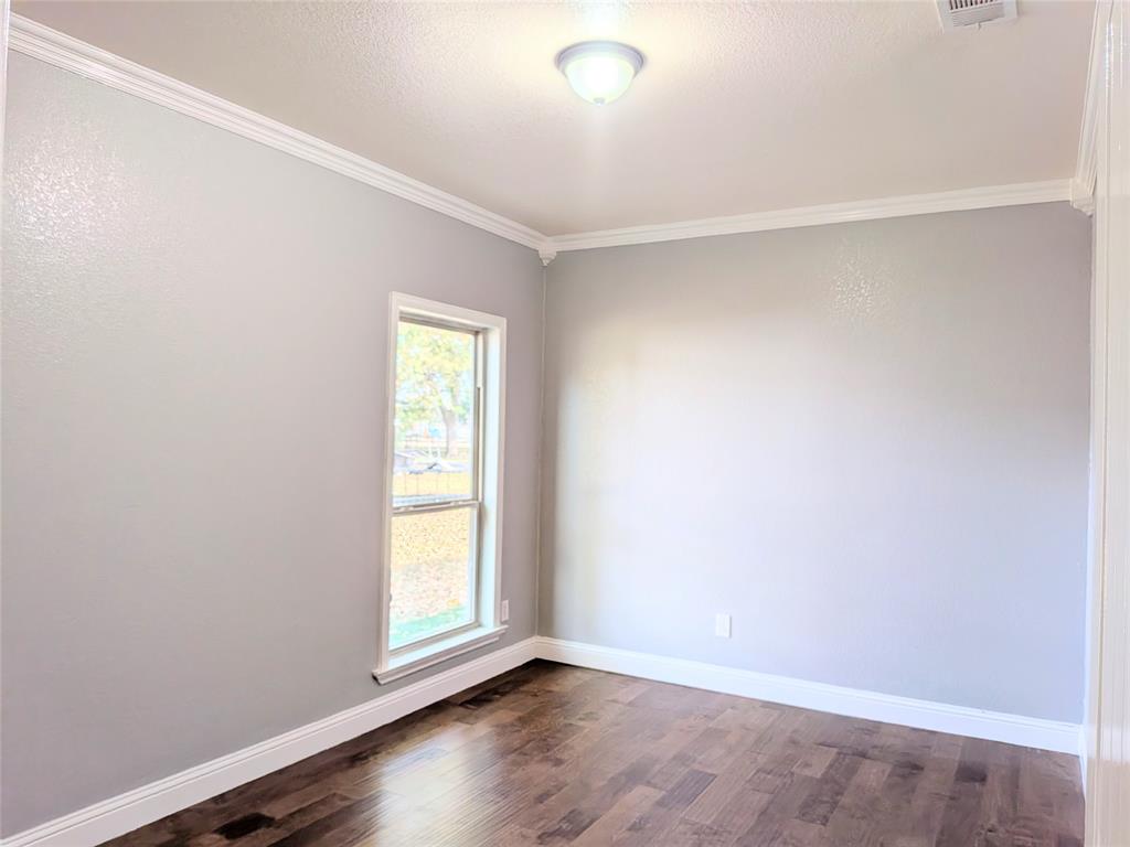 608 Holcomb Road Dallas, TX 75217 - Photo 13 of 23 an empty room with wooden floor and windows