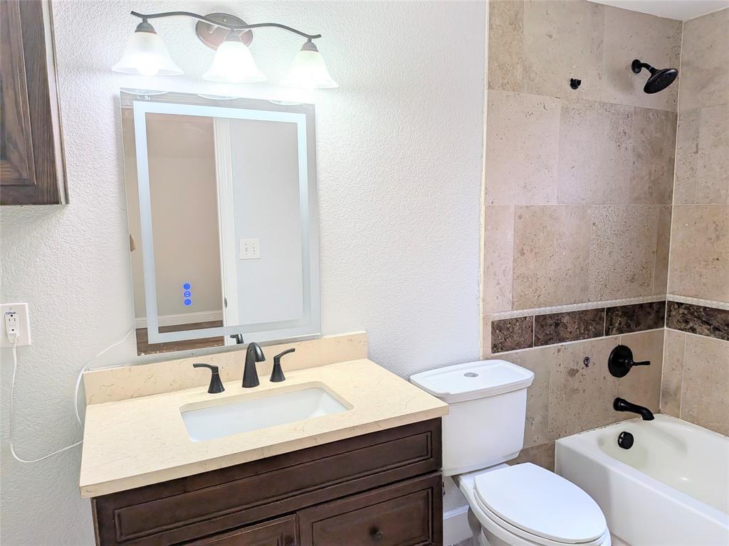 608 Holcomb Road Dallas, TX 75217 - Photo 14 of 23 a bathroom with a sink a toilet and shower
