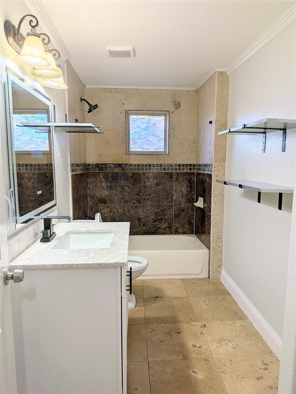 608 Holcomb Road Dallas, TX 75217 - Photo 18 of 23 a bathroom with a bathtub and a sink