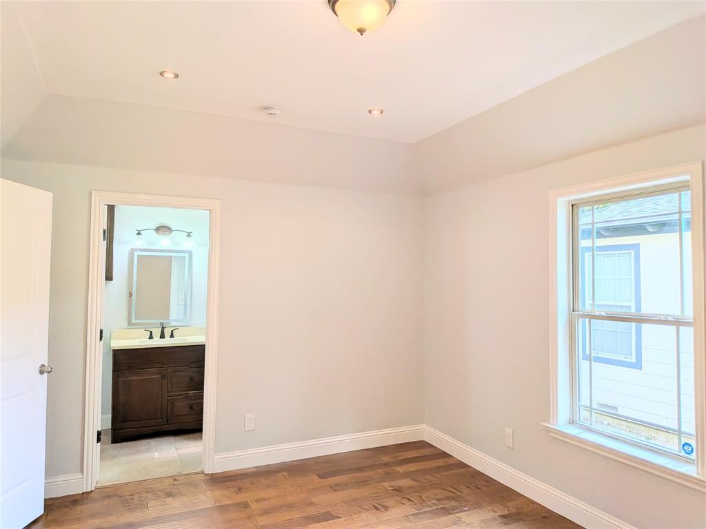 608 Holcomb Road Dallas, TX 75217 - Photo 8 of 23 an empty room with a window and wooden floor