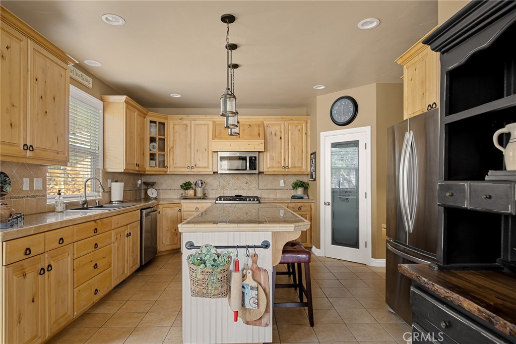 28111 Grenoble Drive Lake Arrowhead, CA 92352 - Photo 17 of 40 a kitchen with stainless steel appliances kitchen island granite countertop a sink a stove a refrigerator and chairs