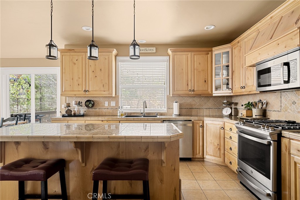 28111 Grenoble Drive Lake Arrowhead, CA 92352 - Photo 19 of 40 a kitchen with stainless steel appliances granite countertop a stove a sink and white cabinets