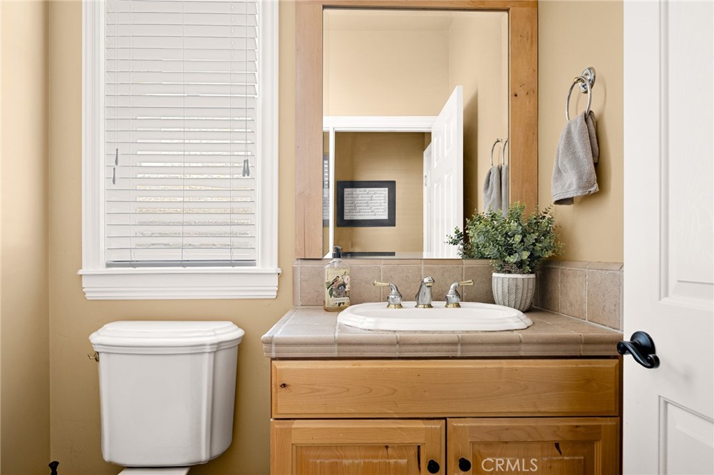 28111 Grenoble Drive Lake Arrowhead, CA 92352 - Photo 22 of 40 a bathroom with a granite countertop sink and a mirror