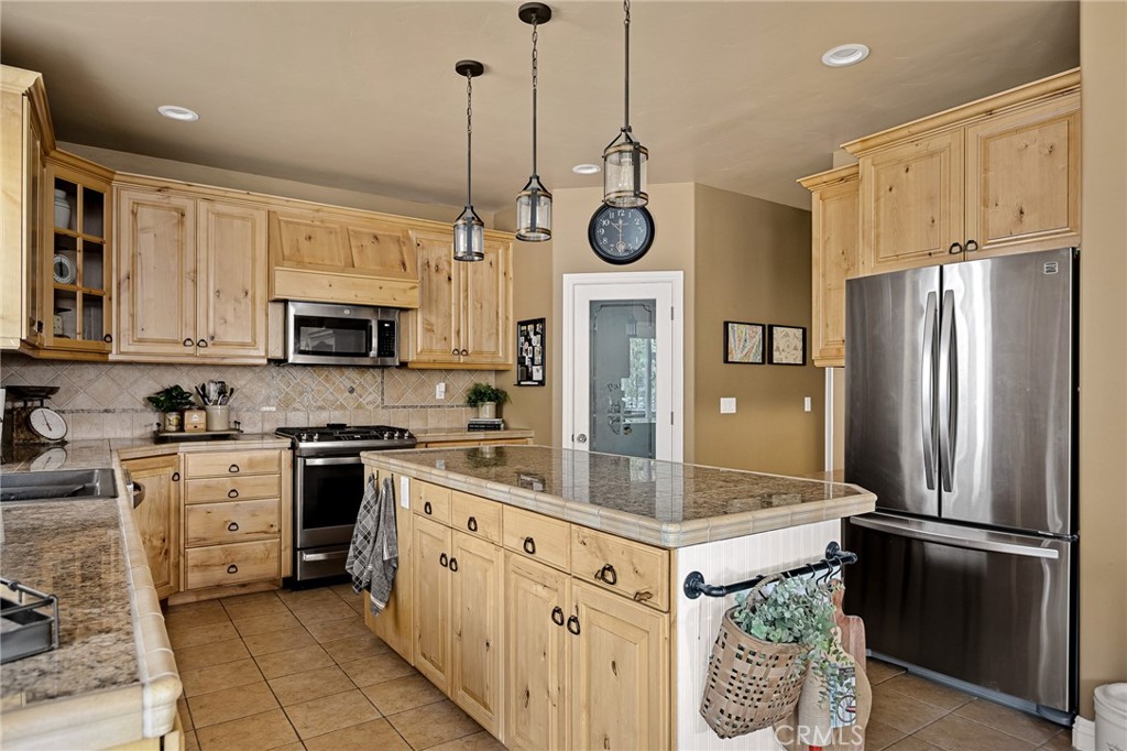 28111 Grenoble Drive Lake Arrowhead, CA 92352 - Photo 6 of 40 a kitchen with stainless steel appliances granite countertop a refrigerator a stove a sink and a microwave