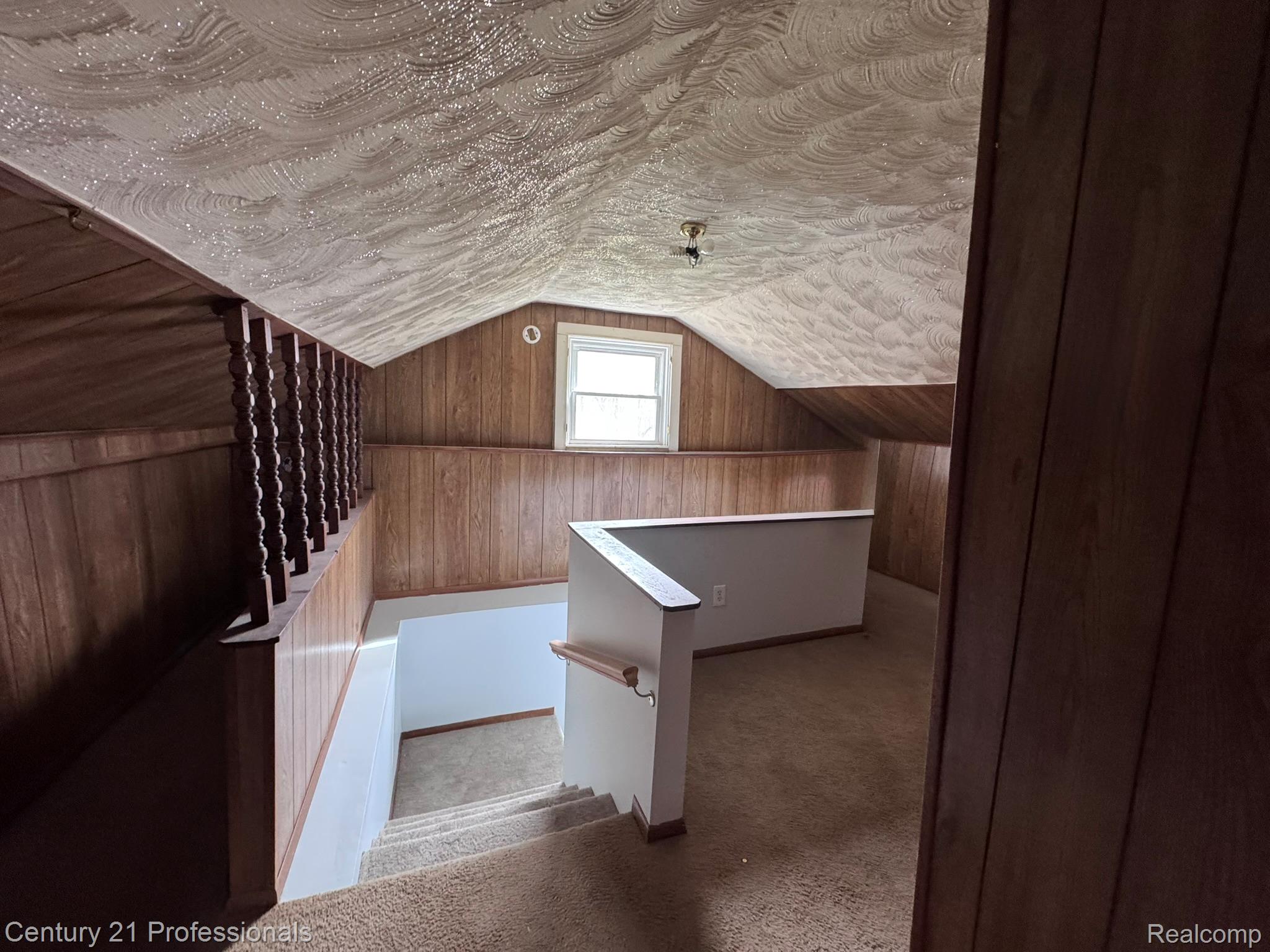 2021 West Rose Center Road Holly, MI 48442 - Photo 29 of 30 Additional living space featuring wood walls, carpet, and a textured ceiling