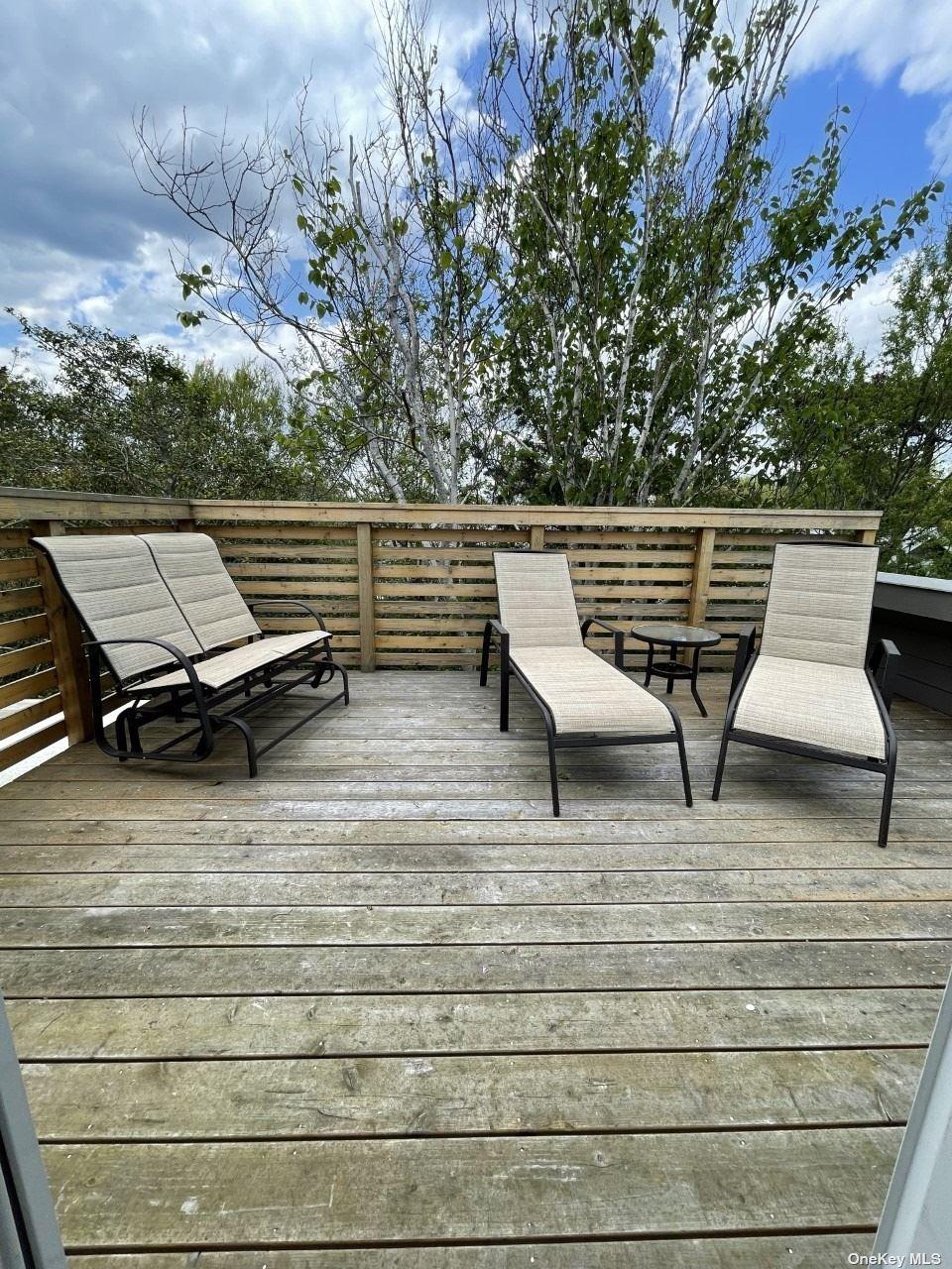 275 Wilmot Road Ocean Beach, NY 11770 - Photo 13 of 19 a roof deck with table and chairs and wooden floor