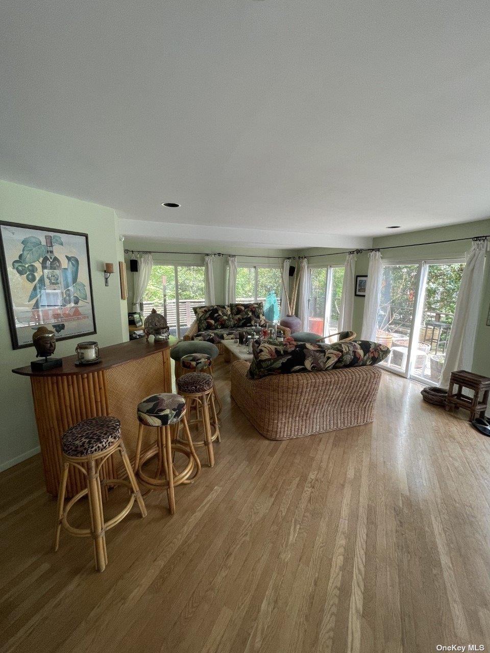 275 Wilmot Road Ocean Beach, NY 11770 - Photo 3 of 19 a living room with furniture a wooden floor and a large window
