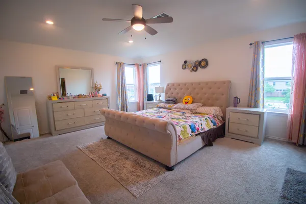 a bedroom with a large bed and a chandelier