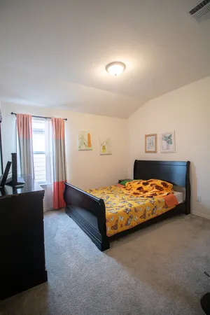 a bed sitting in a bedroom next to a window