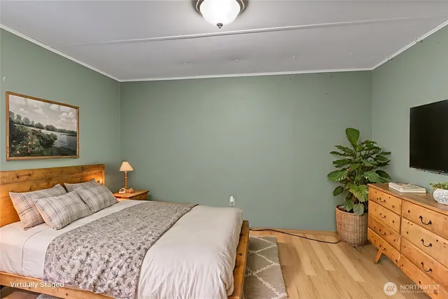 a bedroom with a bed and a flat tv screen on the dresser