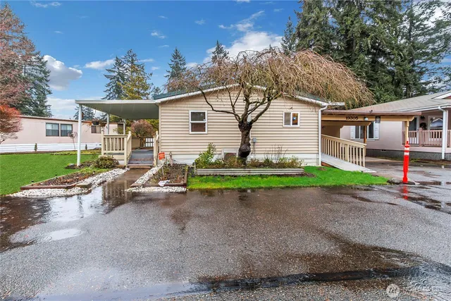 a view of a house with a yard and large trees