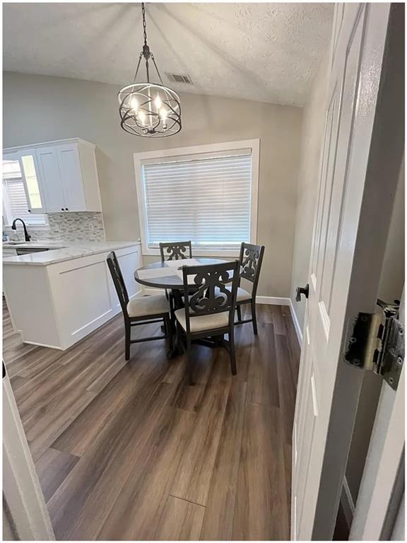 275 Summerfield Crossing Acworth, GA 30101 - Photo 12 of 30 a dining room with wooden floor a chandelier a wooden table and chairs