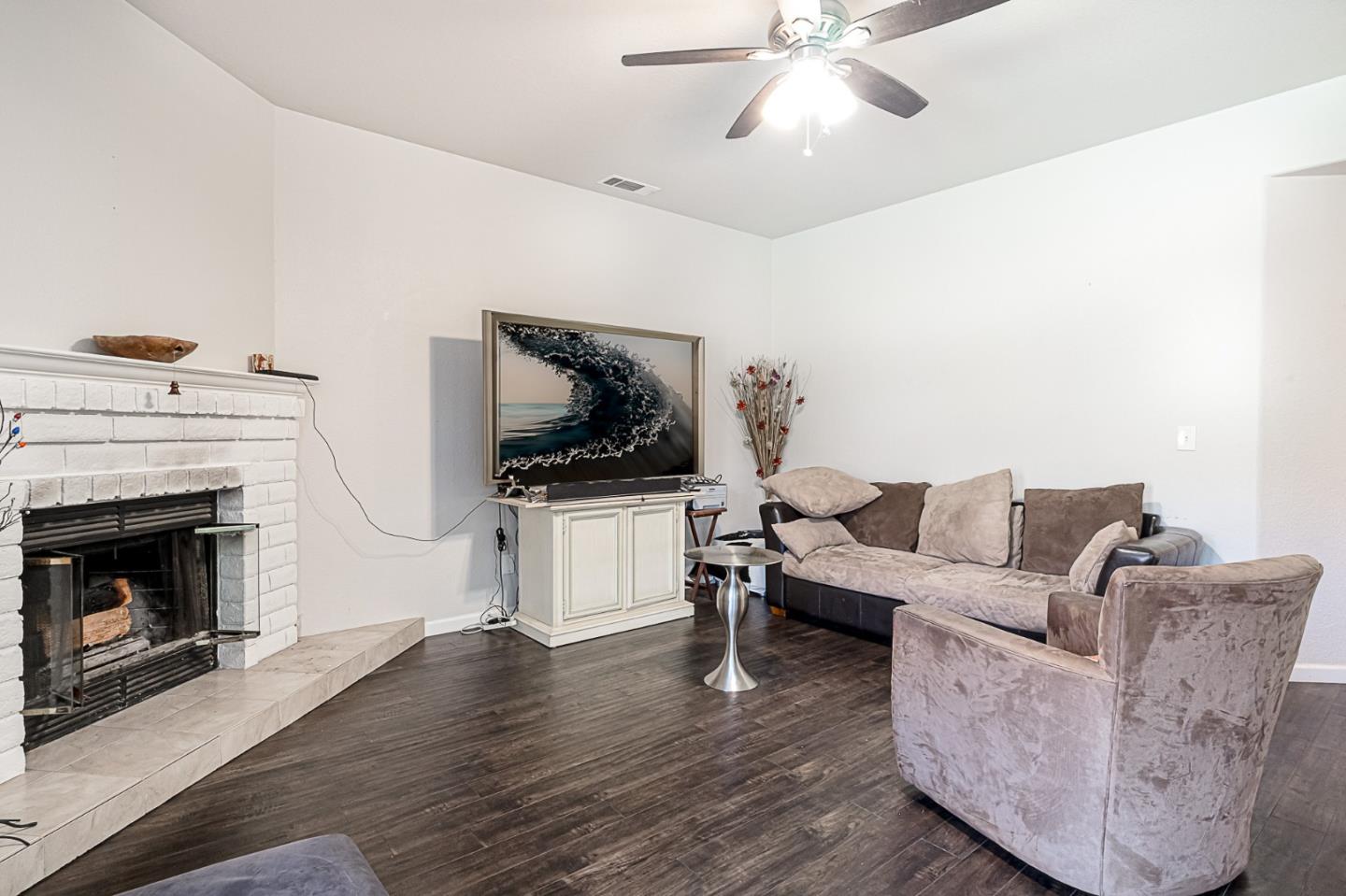 2413 Boston Way Modesto, CA 95355 - Photo 11 of 24 a living room with furniture a flat screen tv and a fireplace