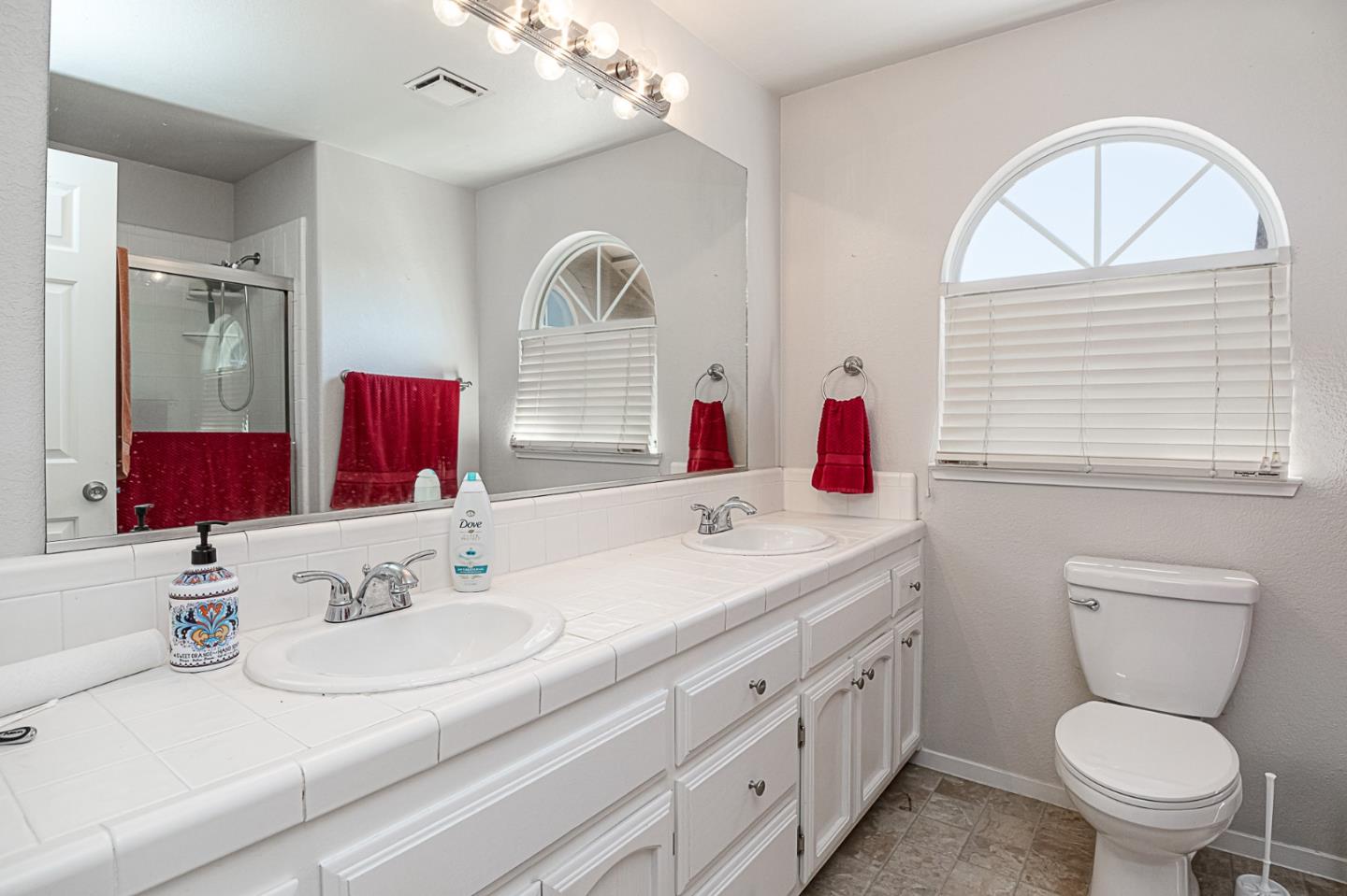 2413 Boston Way Modesto, CA 95355 - Photo 15 of 24 a bathroom with a granite countertop toilet a sink and a mirror