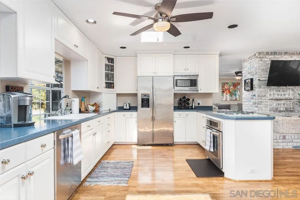 10750 Anaheim Drive La Mesa, CA 91941 - Photo 12 of 34 a kitchen with granite countertop a refrigerator a sink and white cabinets