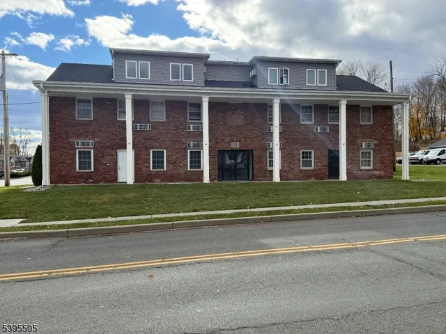 a view of a brick house next to a yard