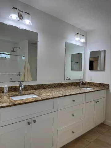 a bathroom with double sink and a mirror