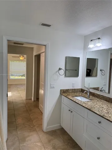 a spacious bathroom with a granite countertop sink and a mirror