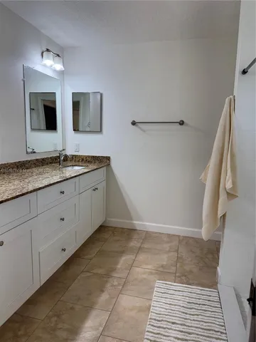 a bathroom with a double vanity sink and mirror