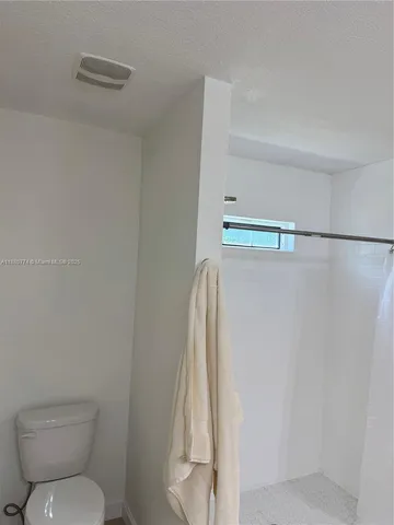 a bathroom with a toilet and a shower