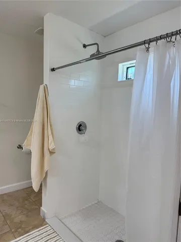 a bathroom with a shower and a glass door