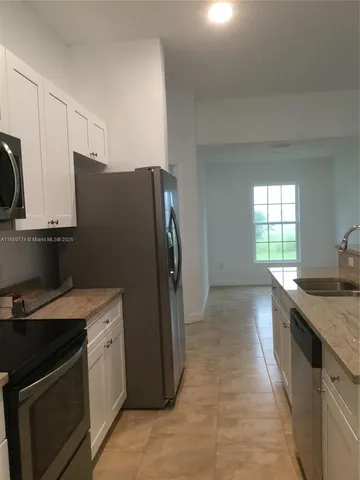 a kitchen with a stove sink and refrigerator