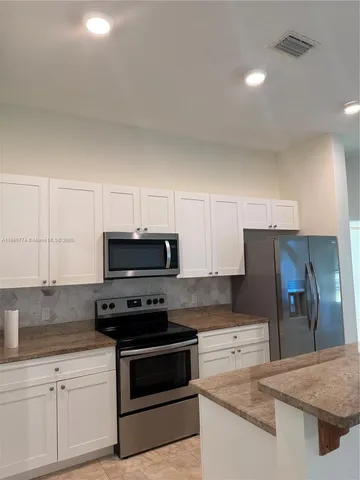 a kitchen with granite countertop a stove and a sink