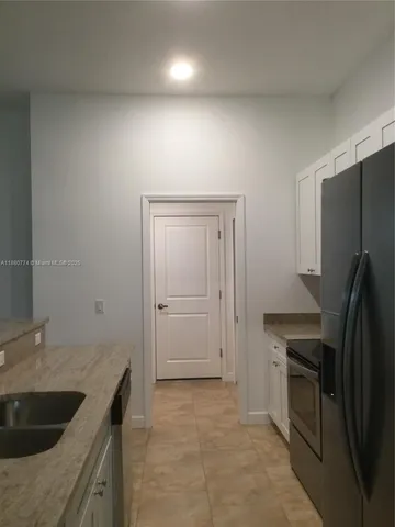 a kitchen with kitchen island a sink stove and refrigerator