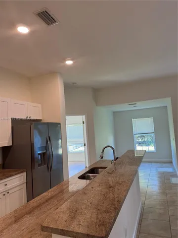 a large kitchen with kitchen island a sink stainless steel appliances and cabinets