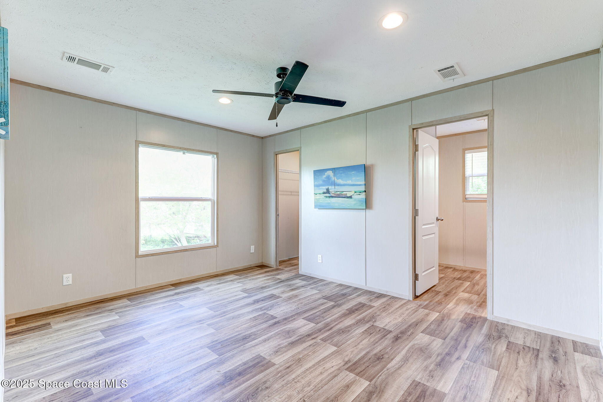 800 Phyllis Way Cocoa, FL 32926 - Photo 18 of 40 a view of an empty room with wooden floor and a window