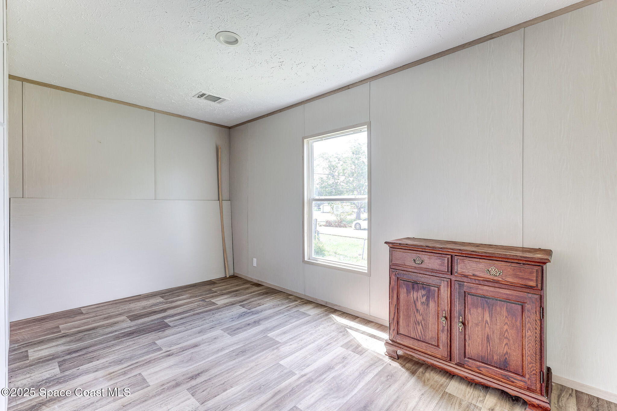 800 Phyllis Way Cocoa, FL 32926 - Photo 25 of 40 wooden floor in an empty room with a window