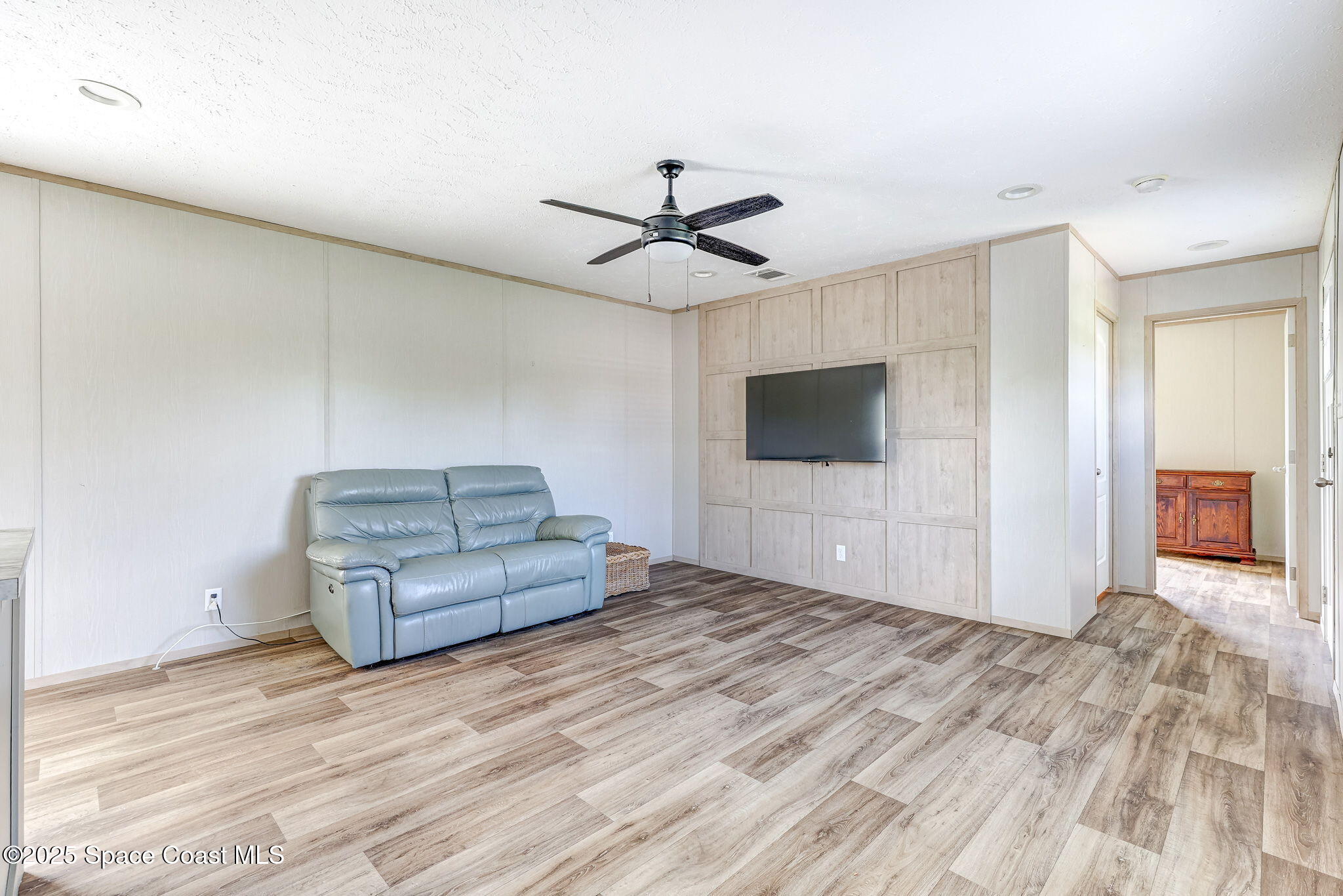 800 Phyllis Way Cocoa, FL 32926 - Photo 5 of 40 a living room with a flat screen tv and a ceiling fan