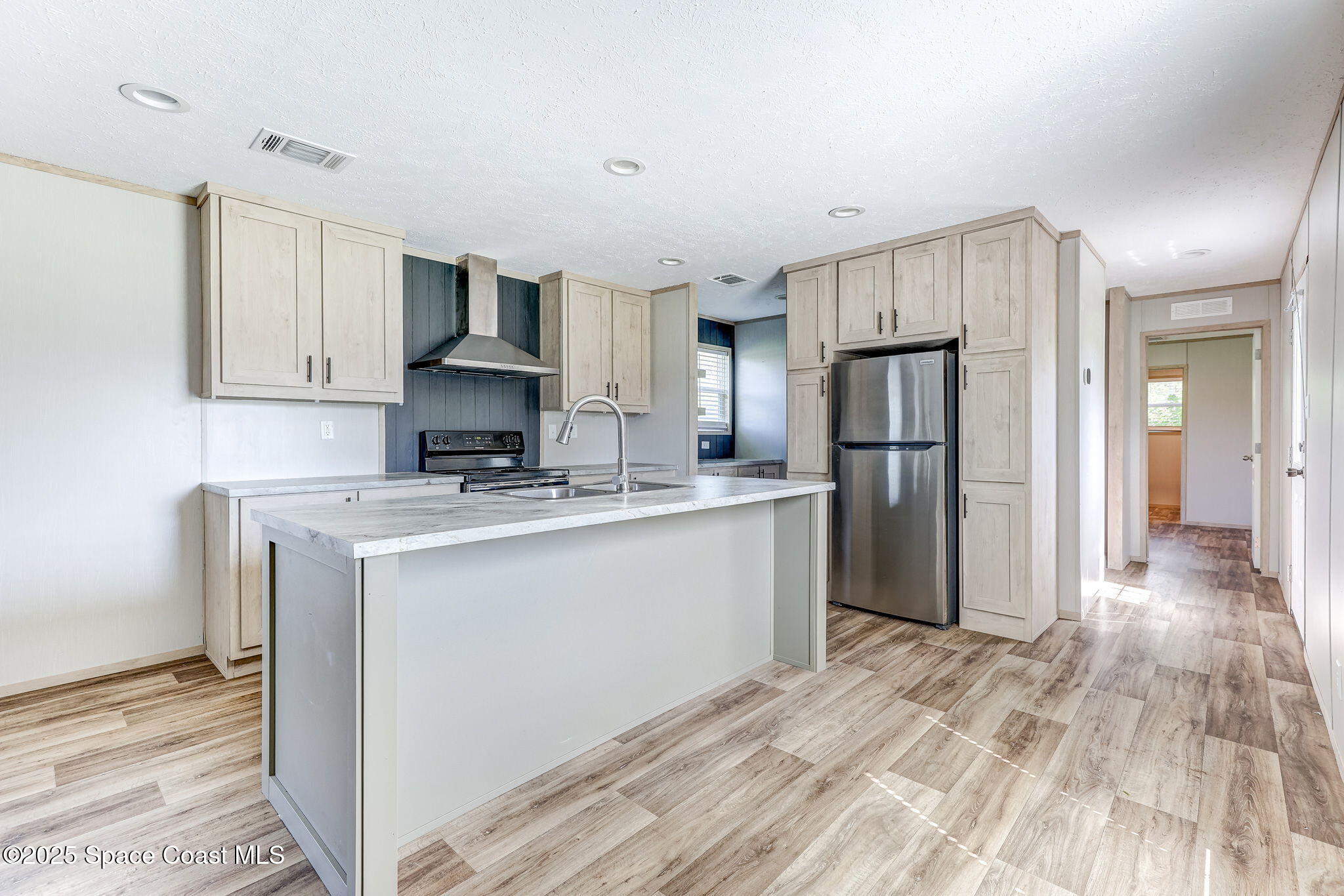 800 Phyllis Way Cocoa, FL 32926 - Photo 7 of 40 a kitchen with stainless steel appliances granite countertop a refrigerator a stove a sink and white cabinets with wooden floor