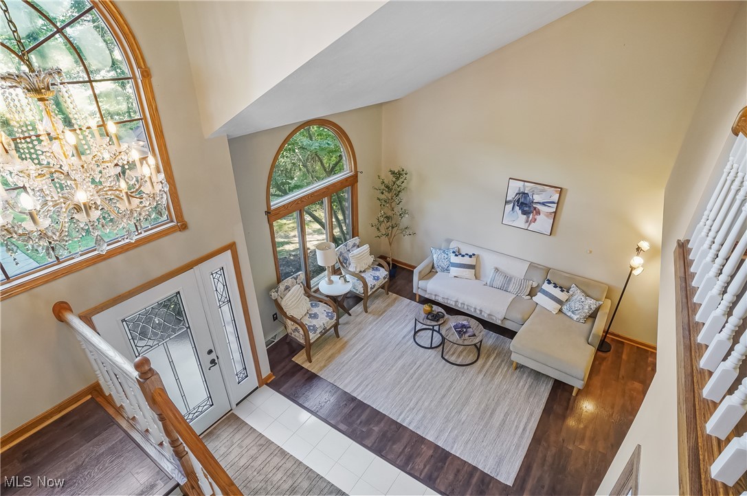 370 Wilcox Road Youngstown, OH 44515 - Photo 21 of 49 Living area featuring high vaulted ceiling, wood finished floors, stairway, and a chandelier