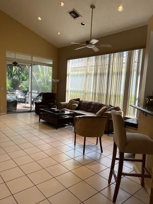 a living room with furniture a flat screen tv and a large window