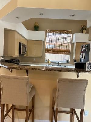 a kitchen with a table chairs microwave and cabinets