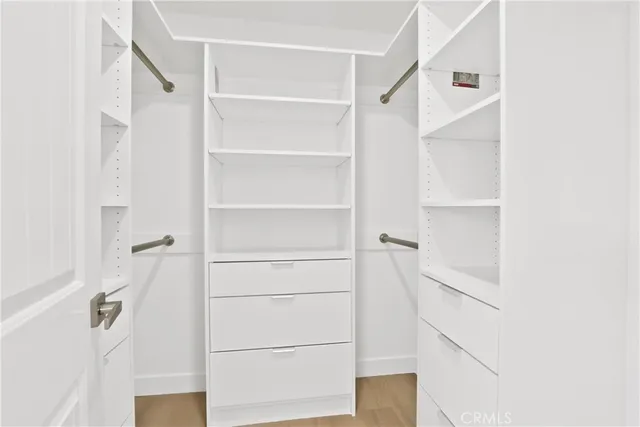 a view of walk in closet with empty racks