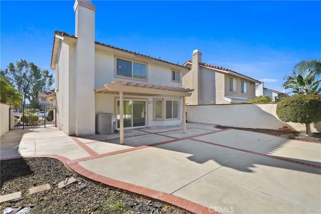 a view of a white house with wooden walls and plants
