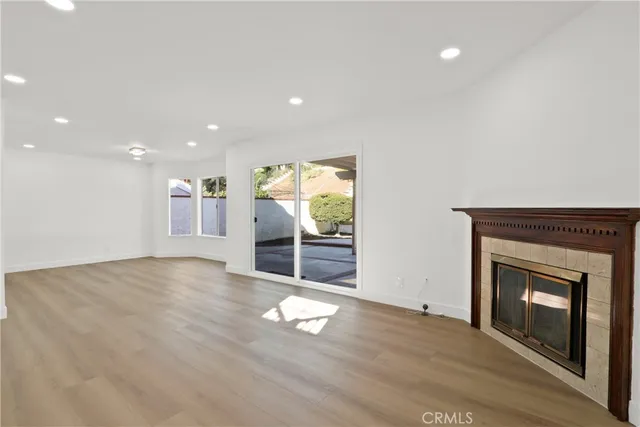 a view of empty room with wooden floor and fireplace