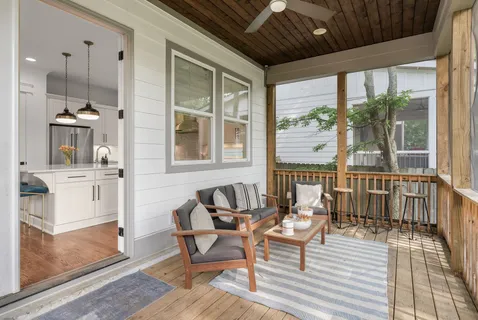 a living room with furniture a large window and wooden floor